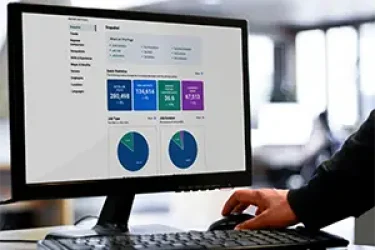 Professional viewing the WE Data Tools Ontario Labour Market Insights Report on a large monitor